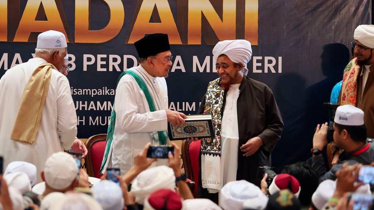 Perdana Menteri Datuk Seri Anwar Ibrahim menyampaikan naskhah Mushaf (al-Quran) Tarim Riwayat ad-Duri ‘an Abi Amr wa al-Basr kepada tokoh ulama besar dunia Islam Al-Habib Umar Muhammad Salim Ben Hafez pada Kuliah Subuh MADANI di Masjid Putra hari ini. - fotoBERNAMA