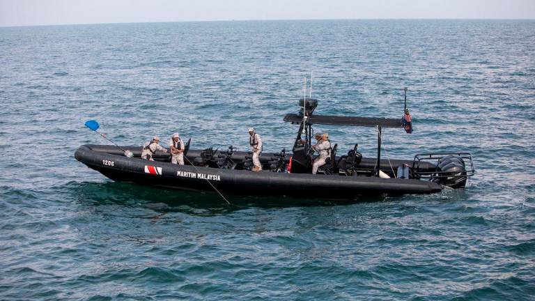 Anggota Agensi Penguatkuasaan Maritim Malaysia (APMM) Perak menunjukkan demonstrasi rampasan bubu naga ketika melakukan tugasan di perairan di sini, baru-baru ini- BERNAMA