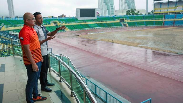 Exco Komunikasi dan Multimedia, Belia, Sukan dan Badan-badan Bukan Kerajaan Pahang Fadzli Mohamad Kamal diberi penerangan oleh Pengurus Perbadanan Stadium Darul Makmur Izad Zainal Muhammad Safian (kiri) tentang fasa akhir kerja-kerja penanaman rumput jenis Bermuda Tifgrand menggunakan keratan akar (stolon) yang telah mula dilakukan di Stadium Darul Makmur - fotoBERNAMA