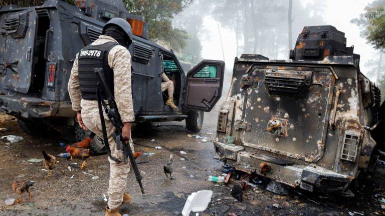 Police officers pass a burnt police armoured personnel carrier after gunmen kidnapped several people from an orphanage in a mountainous community that has been under deadly attacks by armed gangs since the start of this year, on the outskirts of Port-au-Prince, in Kenscoff. Reuterspix