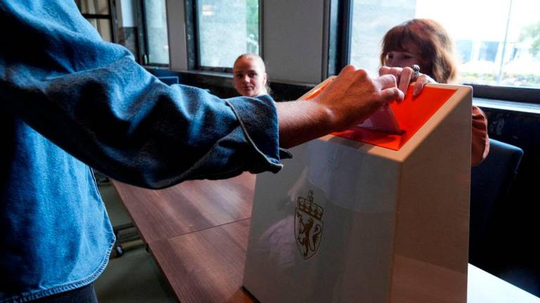 Seorang pengundi membuang undi di sebuah pusat pengundian di Dewan Bandaraya Oslo, semasa pengundian awal bagi pilihan raya parlimen Norway, Norway, 7 September 2025. REUTERS/ Tom Little