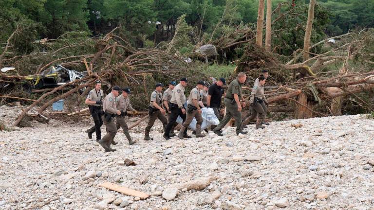 Texas Game Wardens and local law enforcement carry the body of a flood victim from the banks of the Guadalupe River during recovery operations on July 5, 2025 near Hunt, Texas. - AFPpix
