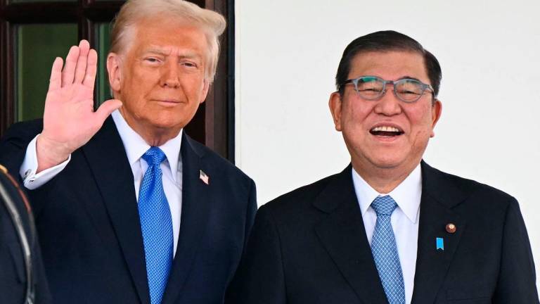 (FILES) US President Donald Trump waves as he greets Japanese Prime Minister Shigeru Ishiba upon arrival outside the West Wing of the White House in Washington, DC, on February 7, 2025. - Mandel NGAN / AFP