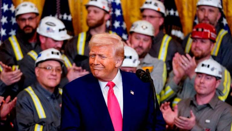 FILEpix U.S. President Donald Trump reacts next to coal industry workers, on the day he signs energy-related executive orders at the White House in Washington, D.C., U.S., April 8, 2025. REUTERSpix