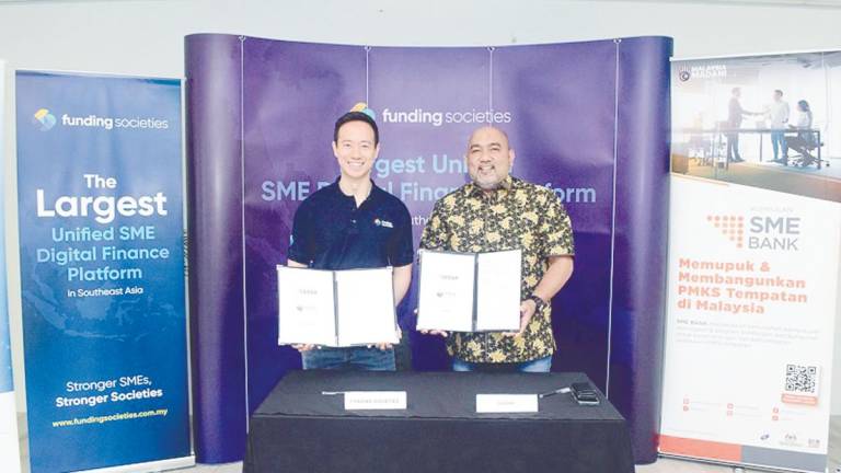 Kah (left) and Hairil Izwar displaying the signed documents.