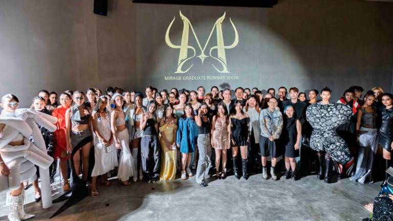 The aspiring fashion designers posing at their graduation show at the Gray Box