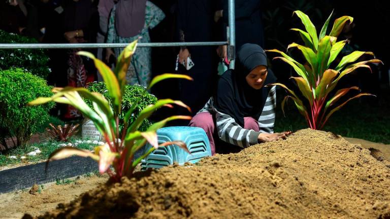 Nur Ayuni Mohd Kamarulzaman, 29, appeared heartbroken after the burial of her son, Muhammad Ammar Muhammad Badrul, 7, who passed away this afternoon after fighting for his life for a week at the Universiti Sains Malaysia Specialist Hospital (HPUSM). He had been assaulted with a hammer by his uncle. The burial took place at the Kampung Mujur Muslim Cemetery, Jelawat, last night. – BERNAMA
