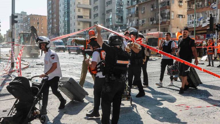 Israeli emergency services help evacuate civilians from the site of an Iranian missile attack in Ramat Gan in central Israel near Tel Aviv, on June 19, 2025. - GIL COHEN-MAGEN