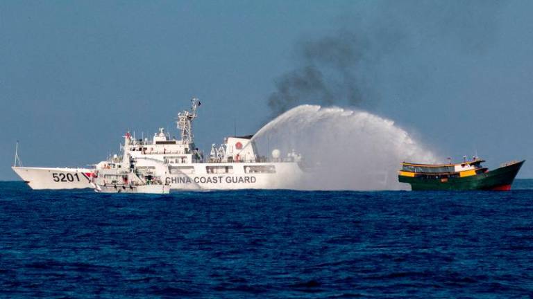 Chinese Coast Guard vessels fire water cannons towards a Philippine resupply vessel Unaizah May 4 on its way to a resupply mission at Second Thomas Shoal in the South China Sea - REUTERSpix