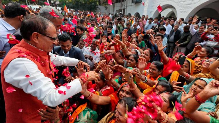 Chief Minister of Madhya Pradesh and member of Bharatiya Janata Party (BJP) Shivraj Singh Chouhan (2L) is greeted by his supporters at his residence in Bhopal on December 3, 2023, following BJP's victory at the Madhya Pradesh assembly elections. - AFPPIX