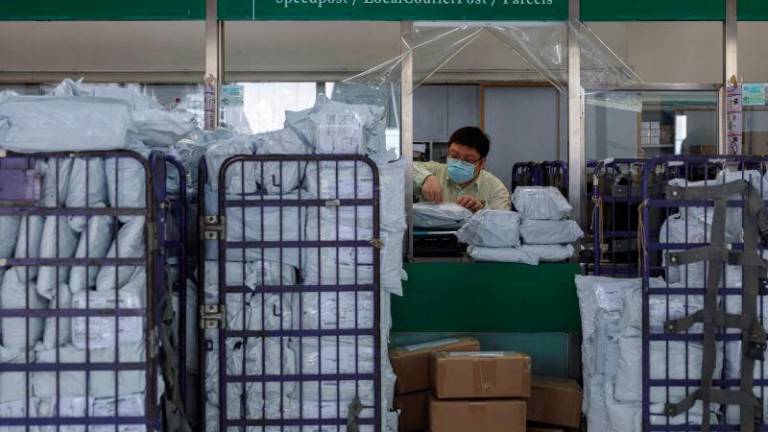 A postal worker processes parcels at a post office as Hong Kong Post restricts U.S.-bound shipments due to new U.S. tariff rules, in Hong Kong, China, May 2, 2025. REUTERSpix