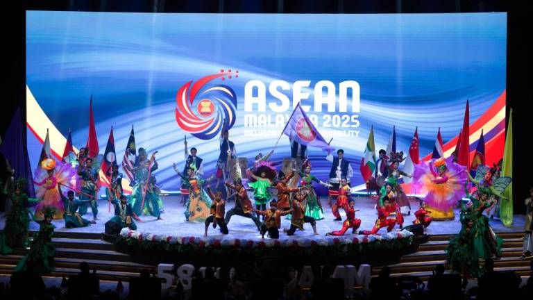 Performers bearing Asean flags pose in conjunction with the 58th Asean Foreign Ministers' Meeting and Related Meetings at the Kuala Lumpur Convention Centre on Wednesday. An economist says Malaysia must consistently support multilateral institutions over the long term and needs to do more to integrate Asean economies, even on a bilateral basis. – Bernamapic