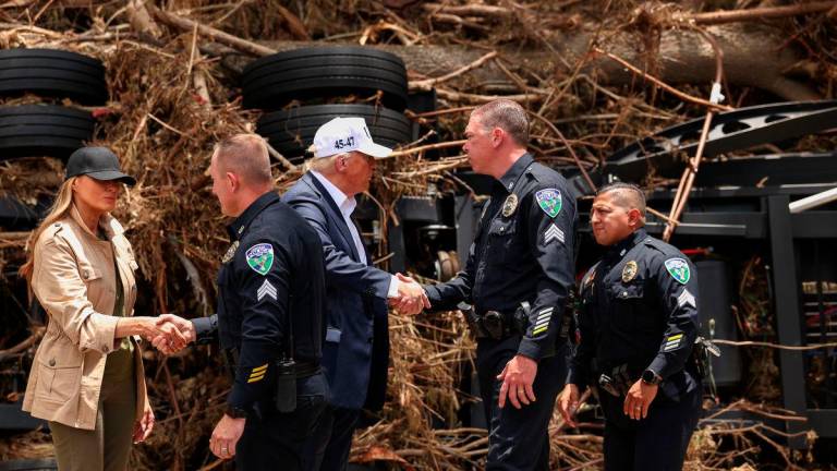 U.S. President Donald Trump and first lady Melania Trump shake hands with Kerrville police officers, as they visit a scene of devastation along the banks of the Guadalupe River, after catastrophic floods, in Kerr County, Texas, U.S., July 11, 2025. REUTERS
