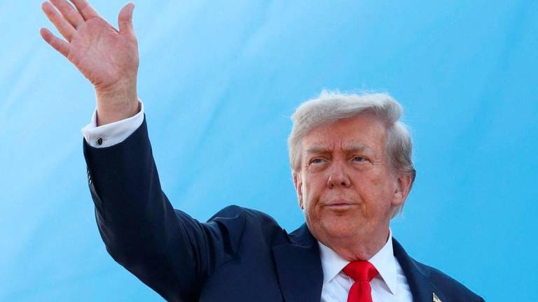 U.S. President Donald Trump waves while boarding Air Force One, as he departs for Alaska to meet with Russian President Vladimir Putin to negotiate for an end to the war in Ukraine, from Joint Base Andrews in Maryland, U.S., August 15, 2025. REUTERS/Kevin Lamarque