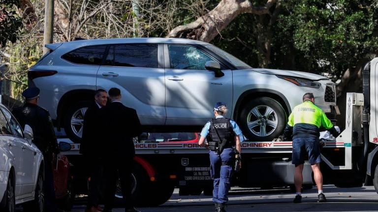 Police officers oversee the loading of a car with a smashed window onto a flatbed truck after it crashed into the Russian consulate in Sydney, Australia, September 1, 2025. REUTERS/Hollie Adams