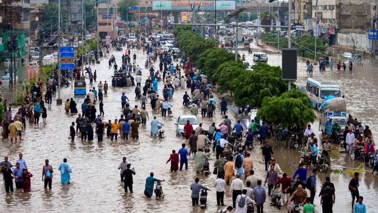Orang ramai meredah jalan yang dinaiki air selepas hujan monsun di Karachi, Pakistan, 19 Ogos 2025. REUTERS/Imran Ali