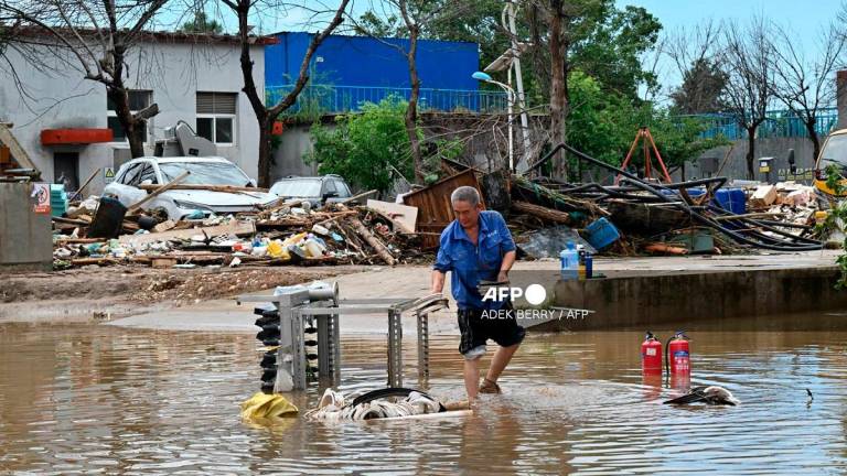 A man salvages items in a flooded area in Miyun district, northern Beijing on July 29, 2025. Heavy rain in Beijing killed 30 people and forced authorities to evacuate tens of thousands as swathes of northern China were lashed by torrential downpours that sparked deadly landslides, state media said on July 29. - ADEK BERRY / AFP