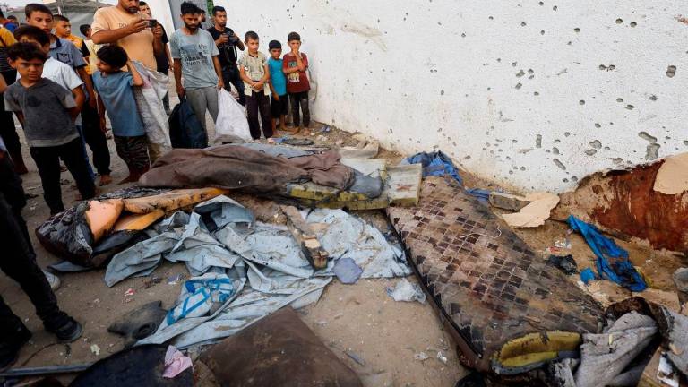 Penduduk Palestin memeriksa kerosakan di lokasi serangan Israel ke atas sebuah khemah berhampiran Hospital Shifa yang mengorbankan wartawan Al Jazeera Anas Al Sharif, Mohammed Qreiqeh, Ibrahim Zaher, dan Mohammed Noufal, di Bandar Gaza pada 11 Ogos 2025 -REUTERS/Mahmoud Issa