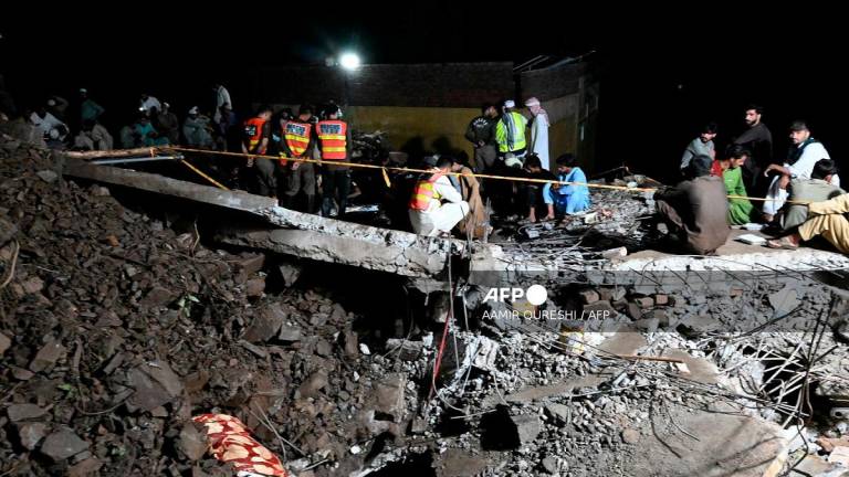 Rescue workers and residents search for victims in the debris of collapsed houses after a cloudburst in Dolari village, Swabi district, in northern Pakistan's mountainous Khyber Pakhtunkhwa province, on August 18, 2025. - Aamir QURESHI / AFP