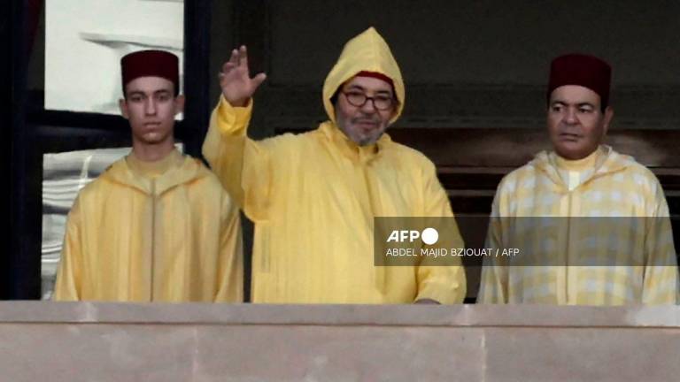 Morocco's King Mohammed VI (C), accompanied by his son, Crown Prince Moulay Hassan (L) appears on the balcony of the Parliament headquarters in Rabat on October 10, 2025. - Abdel Majid BZIOUAT / AFP