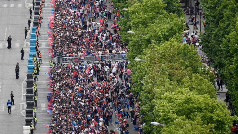 Paris Saint-Germain’s supporters gather as they wait for the team bus to parade on the Champs-Elysees avenue in Paris on June 1, 2025, a day after PSG won the 2025 UEFA Champions League final football match against Inter Milan in Munich. (Photo by Guillaume SOUVANT / AFP)