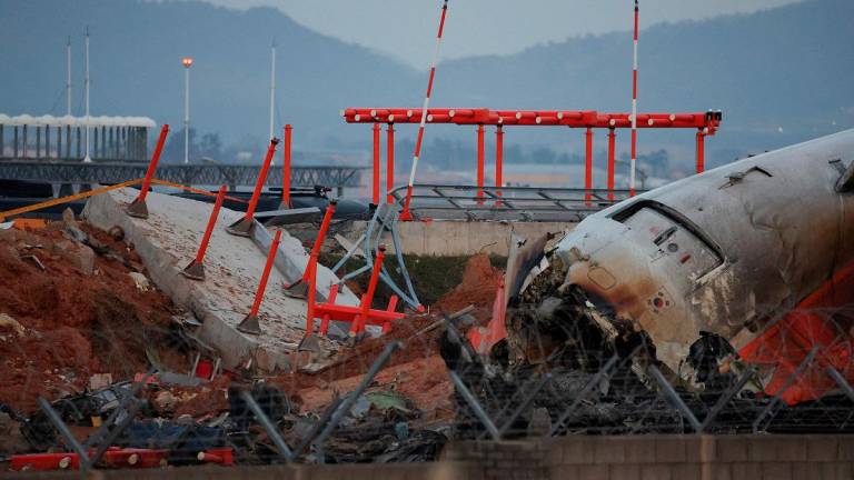 The wreckage of the Jeju Air aircraft that went off the runway and crashed at Muan International Airport lies near a concrete structure it crashed into, in Muan, South Korea, December 30, 2024. - REUTERS/Kim Hong-Ji/File Photo
