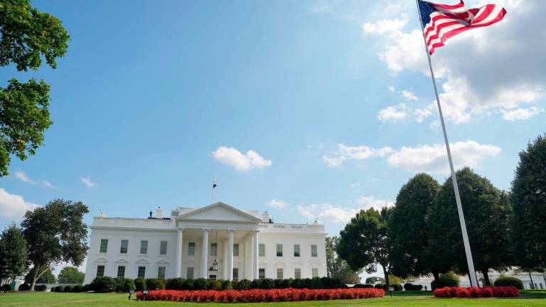The U.S. flag flutters as people demonstrate in front of the White House after U.S. President Donald Trump deployed National Guard and ordered an increased presence of federal law enforcement to assist in crime prevention, in Washington, D.C., U.S., August 16, 2025. REUTERS/Ken Cedeno