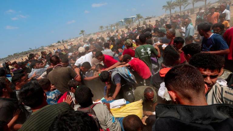 Palestinians gather to receive aid packages, in Deir Al-Balah, in the central Gaza Strip August 18, 2025. - REUTERSPIX