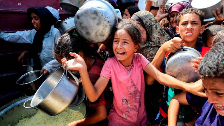 Warga Palestin menunggu untuk menerima makanan daripada dapur amal di Khan Younis, selatan Semenanjung Gaza, 21 Ogos 2025. REUTERS/Hatem Khaled TPX IMAGES OF THE DAY