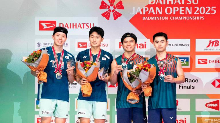 Winners South Korea's Kim Won-ho and Seo Seung-jae (L) and runners-up Malaysia's Goh Sze Fei and Nur Izzuddin pose on the podium after their men's doubles final match on the final day of the Japan Open badminton tournament at Tokyo Gymnasium in Tokyo on July 20, 2025. - Yuichi YAMAZAKI / AFP