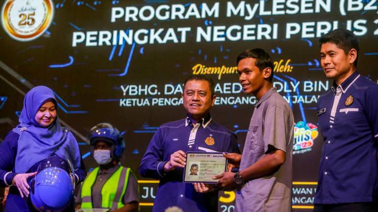 Ketua Pengarah Pengangkutan Jalan Malaysia, Datuk Aedy Fadly Ramli (tiga, kiri) menyerahkan lesen pandu uji simbolik kepada Khosit Sommai (empat, kiri) pada Majlis Penyerahan Lesen Memandu Program MyLesen (B2) peringkat negeri Perlis di Dewan Warisan, Kangar, Mei 30 di Kangar.