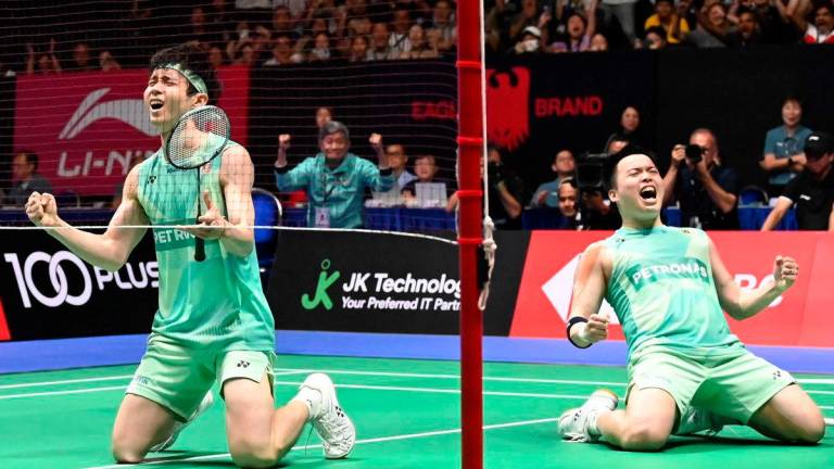 Aaron Chia and Soh Wooi Yik of Malaysia celebrate their victory against Kim Won-ho and Seo Seung-jae of South Korea in their men’s doubles final match at the Singapore Open badminton tournament in Singapore on June 1, 2025.. AFPpix