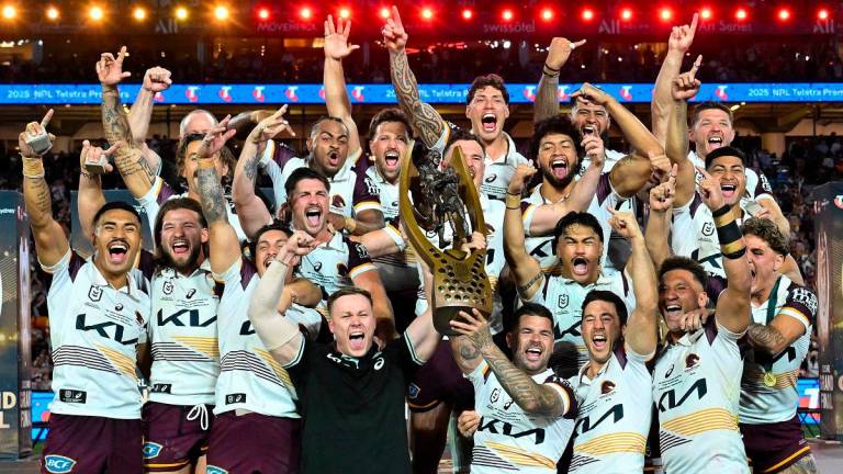 Brisbane Broncos’ players celebrate with the trophy after winning the National Rugby League (NRL) Grand Final match between Melbourne Storm and Brisbane Broncos at Accor Stadium in Sydney on October 5, 2025. - Izhar KHAN / AFP