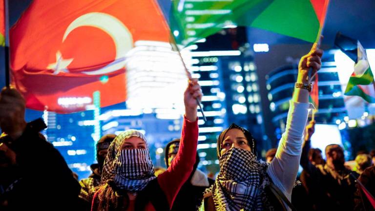 Demonstrators wave Palestinian and Turkish flags during a rally in solidarity with Palestinians and to condemn the interception of the Global Sumud Flotilla by Israeli army, in Istanbul on October 2, 2025. (Photo by KEMAL ASLAN / AFP)