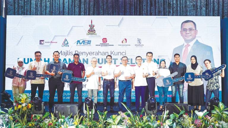 Amirudin and recipients at the key handover ceremony for the Idaman Bukit Jelutong condominium today. – Bernamapic