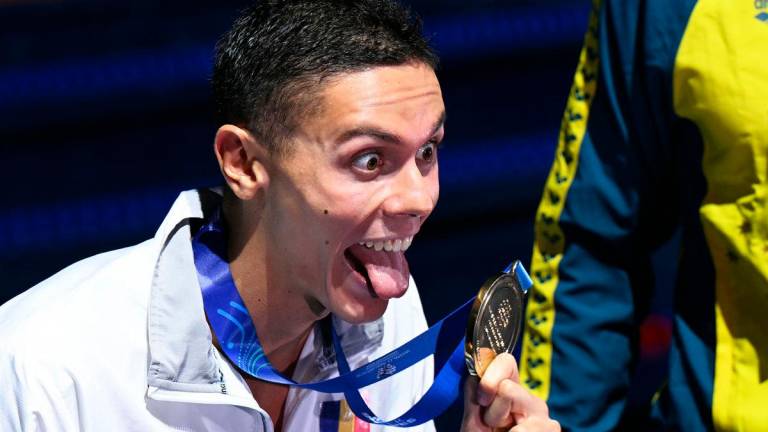 Gold medallist Romania’s swimmer David Popovici celebrates on the podium of the men’s 100m freestyle swimming event during the 2025 World Aquatics Championships in Singapore on July 31, 2025. - Oli SCARFF / AFP