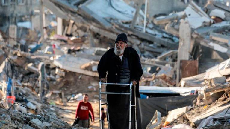 For representational purposes - An elderly man moves with a walker past rubble along a broken road as people displaced by conflict from Beit Lahia arrive in Gaza City. AFPpix