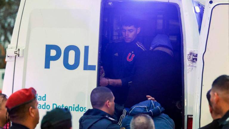 Detained fans of Universidad de Chile get into a police vehicle to be transferred by the Buenos Aires Province Police from a police station in Avellaneda, Buenos Aires province, Argentina. AFP