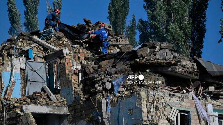 Ukrainian rescuers carry the body of a victim recovered during a search and rescue operation at the site of a residential building, heavily damaged following a Russian missile strike in Kyiv on August 28, 2025, amid the Russian invasion of Ukraine. - Genya SAVILOV / AFP