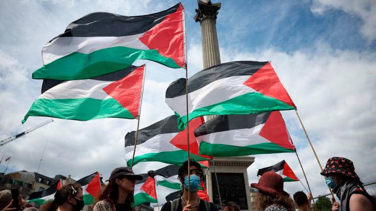 Flags of Palestine fly during a protest in support of pro-Palestinian group Palestine Action, in Trafalgar Square, central London, on June 23, 2025. (Photo by HENRY NICHOLLS / AFP)