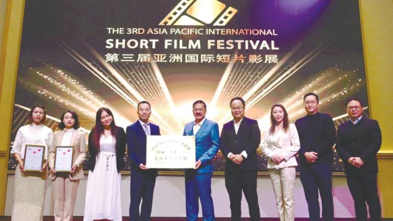 China Fengqing Dianhong Tea Industry Alliance president Zhang Guijing (centre, left) presenting a plaque to NCT Group executive director Datuk Joe Yap Fook Choy (centre, right) at the unveiling ceremony.