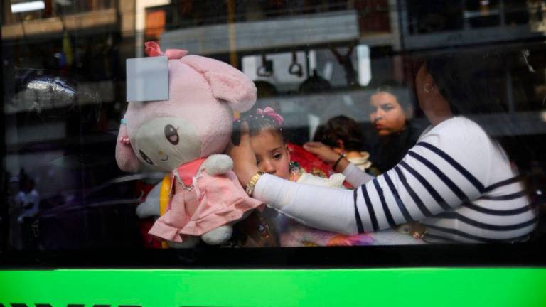 A migrant girl from Venezuela looks on through the window of the bus taking her and her family to their embassy, while on their way to take a flight back to Venezuela, in Mexico City, Mexico May 7, 2025. REUTERSpix