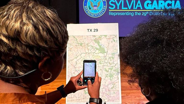 Voters look at a map to understand the new redistricting maps approved by Texas lawmakers for the 2026 midterm elections, at San Jacinto College in Houston, Texas, on August 27, 2025. - MOISES AVILA / AFP