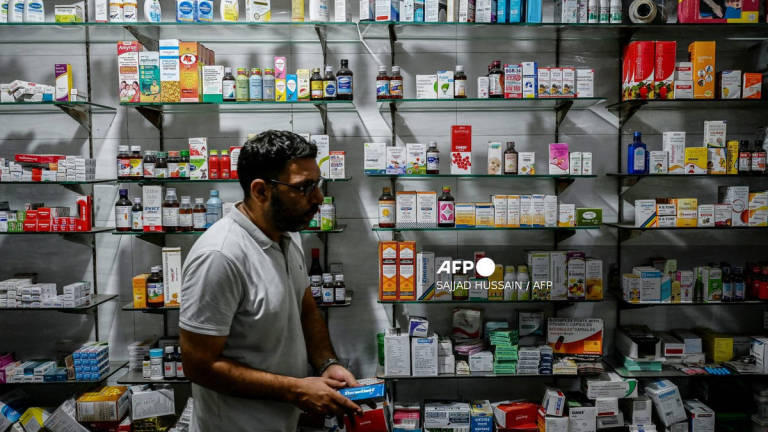 A pharmacist works at his shop in New Delhi on July 31, 2025. - AFP