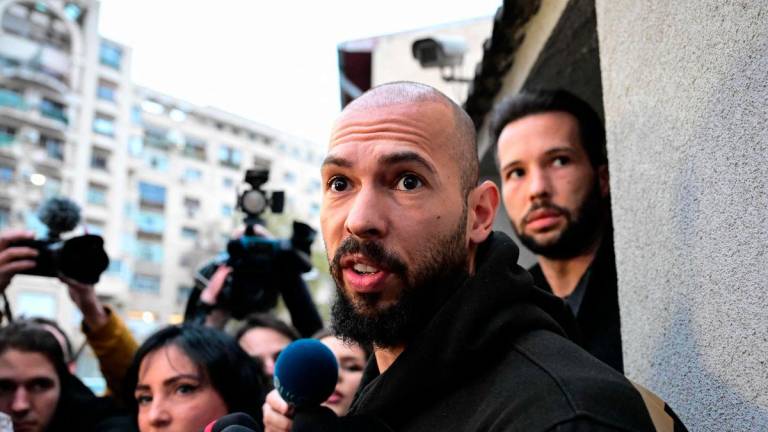 FILEpix: Andrew Tate (C) and his brother Tristan Tate (R) speak to journalists after having been released from detention in Bucharest, Romania on March 12, 2024,. AFPpix