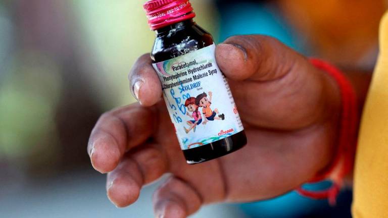 Nilesh Suryavanshi, 32, the father of a 3 year old child who has been admitted at the Government Medical College, holds a bottle of Coldrif cough syrup, which has been linked to the deaths of 17 children, in Nagpur, India, October 8, 2025. REUTERS/Priyanshu Singh