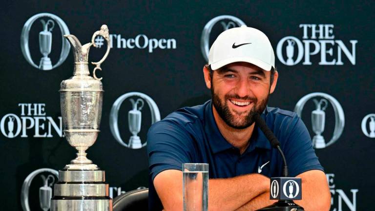 US golfer Scottie Scheffler with the Claret Jug, the trophy for the Champion golfer of the year beside him, holds a press conference after his victory in the 153rd Open Championship at Royal Portrush golf club in Northern Ireland on July 20, 2025 - AFP