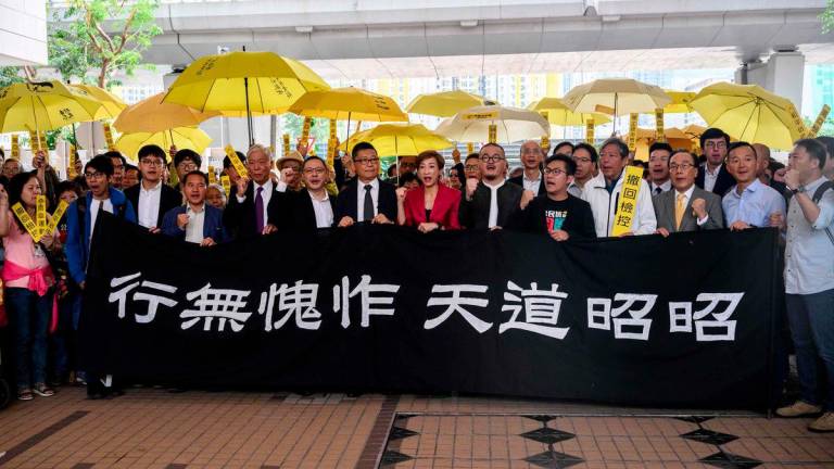 (L-R behind banner) Pro-democracy activists Chung Yiu-wa, Cheung Say-yin, former Democratic Party lawmaker Lee Wing-tat, baptist minister Chu Yiu-ming, 74, law professor Benny Tai, 54, sociology professor Chan Kin-man, 59, lawmakers Tanya Chan and Shiu Ka-chun, and League of Social Democrats vice-chairman Raphael Wong, chant before entering the West Kowloon Magistrates Court in Hong Kong on November 19, 2018. - AFPPIX