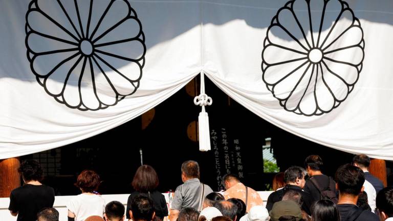 People pray as they pay tribute at the Yasukuni Shrine on the 80th anniversary of Japan’s surrender in World War Two, in Tokyo, Japan, August 15, 2025. REUTERS/Manami Yamada