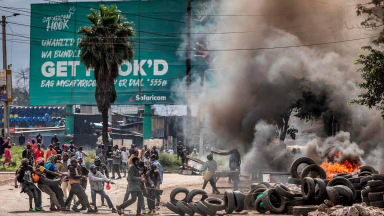 Protesters block a main road with tyres and burning barricades during clashes with Kenya police officers at Saba Saba Day demonstrations in Nairobi on July 7, 2025. (Photo by Luis TATO / AFP)